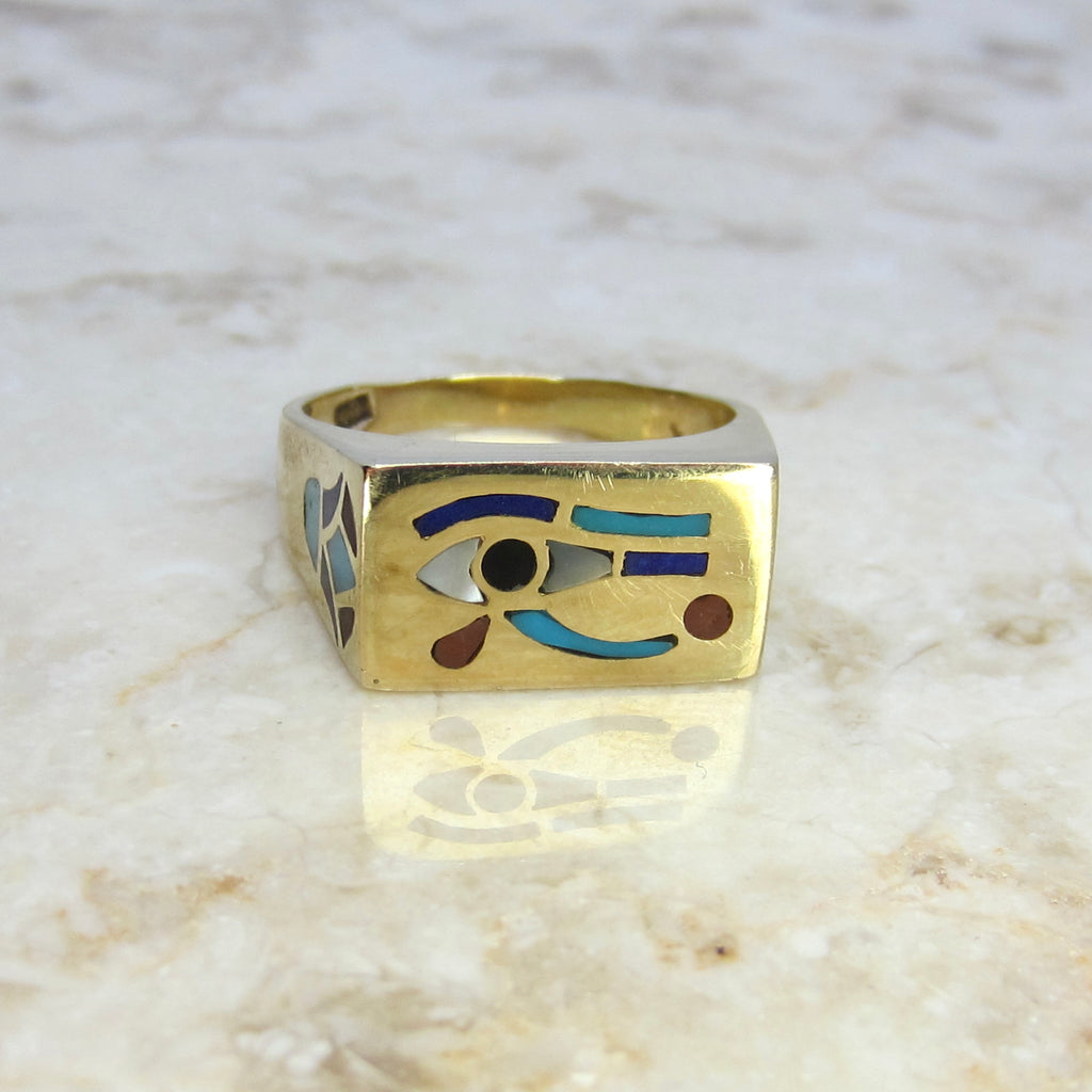 Gold ring with eye design on a marble surface