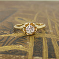 Gold ring with a diamond on a textured gold surface