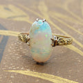 Opal ring with gold setting on a textured surface
