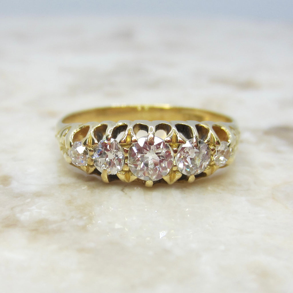 Gold ring with diamonds on a marble surface