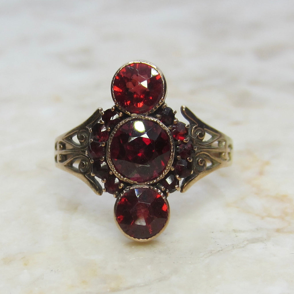 Ring with red gemstones on a marble surface