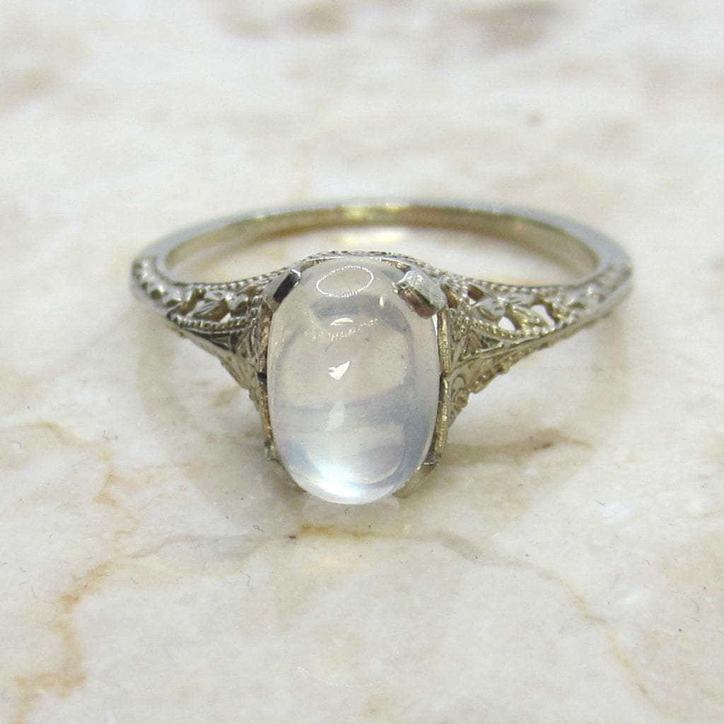 Silver ring with a central gemstone on a marble surface