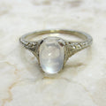 Silver ring with a central gemstone on a marble surface