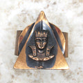 Bronze or gold pharaoh head design on a stone surface