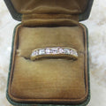 Gold ring with diamonds in a brown velvet box on a marble surface